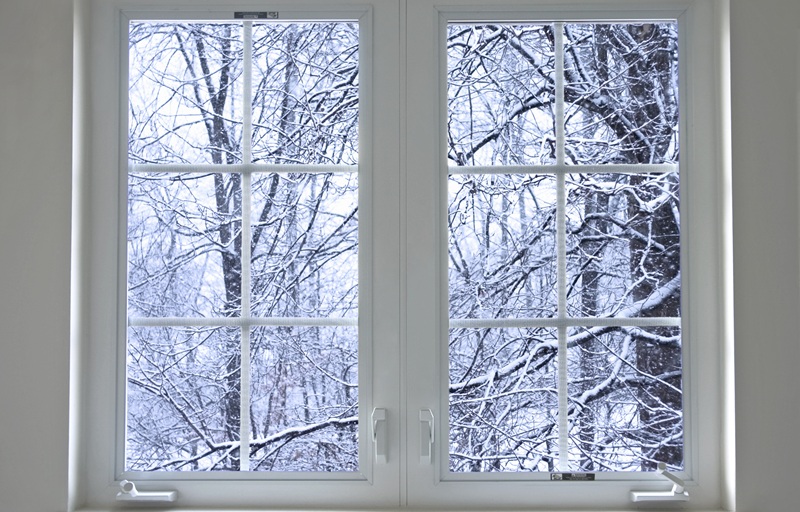 Residential home window with the outside being covered in snow.